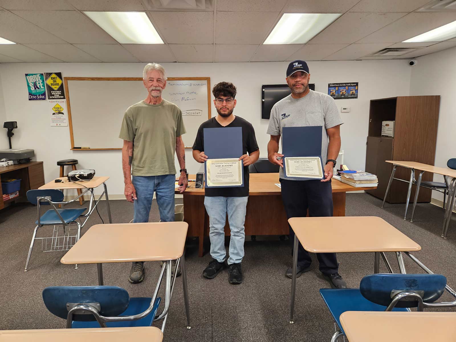 men with certificates in classroom